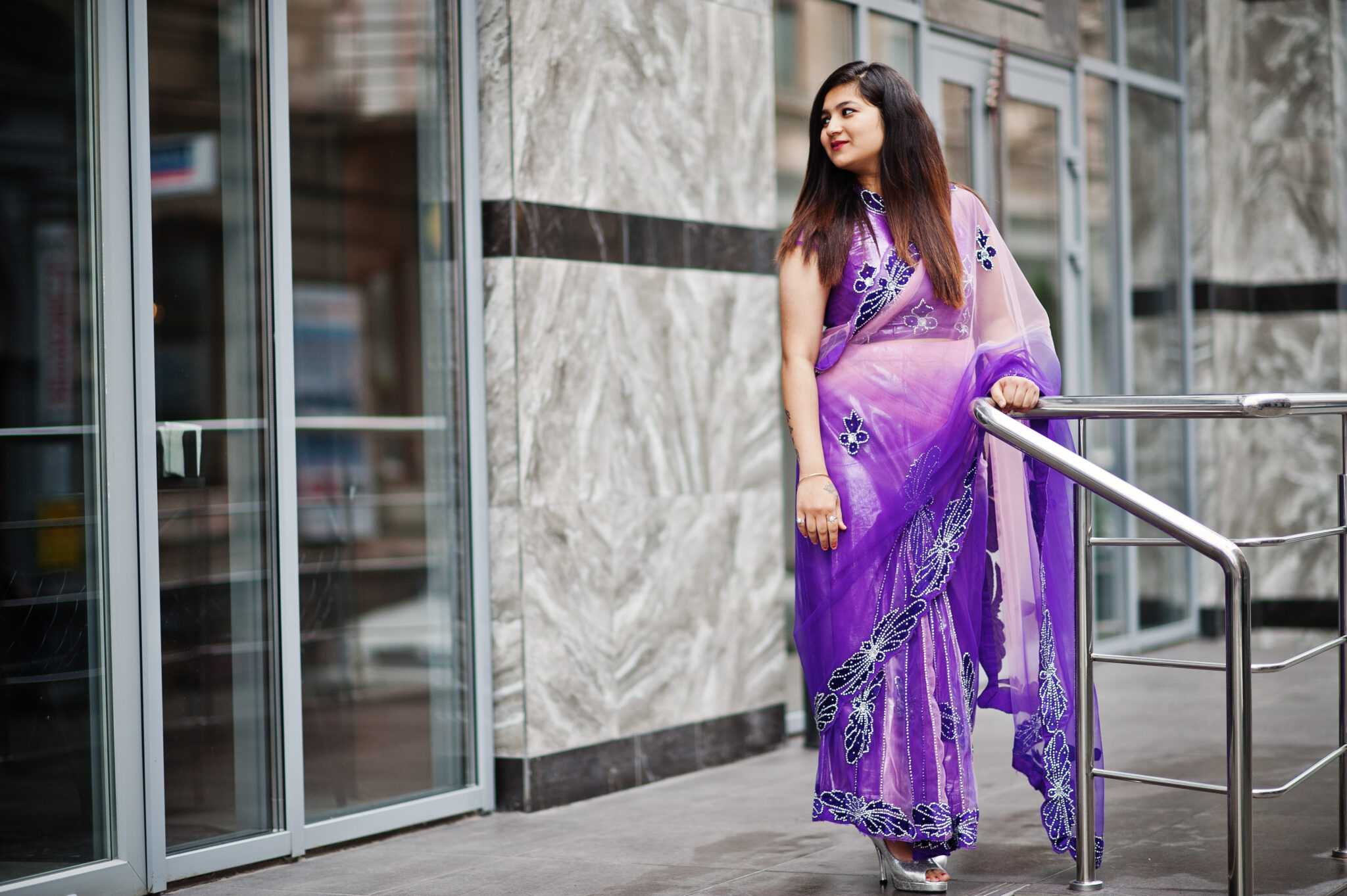 Indian hindu girl at traditional violet saree posed at street.